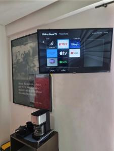 a flat screen tv on a wall with a coffee machine at Flat Beira Mar Terrazzas in João Pessoa