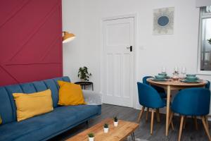 - un salon avec un canapé bleu et une table dans l'établissement The Ferndale - Spacious 3 Bed Apartment, à Pallion
