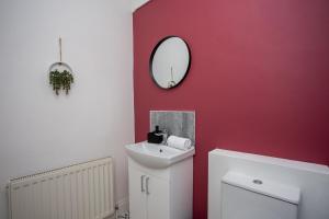 a bathroom with a sink and a mirror on the wall at The Ferndale - Spacious 3 Bed Apartment in Pallion