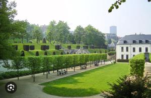 un parque con una fila de árboles y un edificio en Ravissant appartement Louisa, en Bruselas