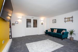 uma sala de estar com um sofá verde e um tapete em Stephenson's Lodge - Stylish One Bed - City Centre em Sunderland