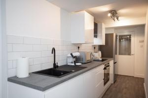 a kitchen with a sink and a counter top at Stephenson's Lodge - Stylish One Bed - City Centre in Sunderland