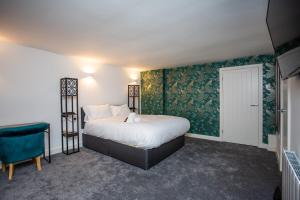a bedroom with a bed and a green wall at Stephenson's Lodge - Stylish One Bed - City Centre in Sunderland