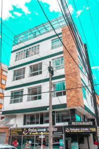 ein hohes weißes Gebäude an der Ecke einer Straße in der Unterkunft apt duplex embajada americana corferias agora g12 in Bogotá