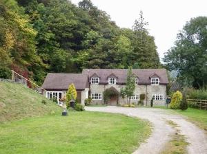 a large stone house with a gravel driveway at Quarry House in Presteigne