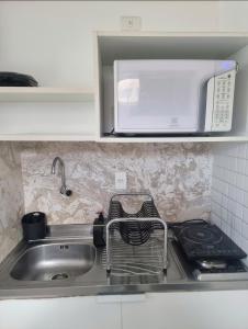 a kitchen counter with a sink and a microwave at Flat Beira Mar Terrazzas in João Pessoa