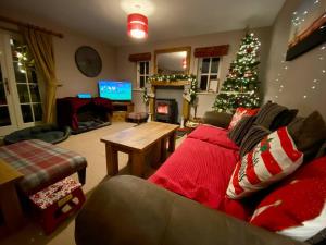 een woonkamer met een kerstboom en een bank bij Quarry House in Presteigne