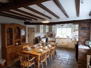 een grote keuken met een houten tafel en stoelen bij Quarry House in Presteigne