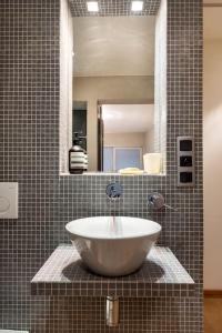 een badkamer met een grote wastafel in een tegelwand bij Seafront apartment 2 bed Duinbergen in Knokke-Heist