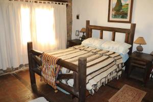 sypialnia z dużym łóżkiem z drewnianą ramą w obiekcie Los Abuelos w mieście Anillaco