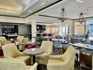 a lobby with tables and chairs and a cafeteria at ACP Hotel Westchase in Houston