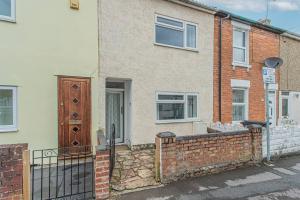 a brick house with a gate and a fence at Lorne Lodge Central Swindon in Swindon
