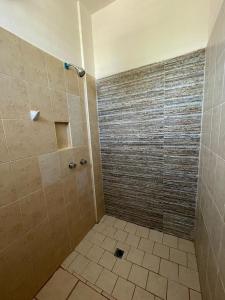 Łazienka z prysznicem i podłogą wyłożoną kafelkami w obiekcie Hotel Albatros w mieście Peñita de Jaltemba