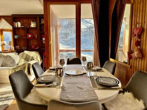 un tavolo da pranzo con sedie, un tavolo e una finestra di Luxury 4beds ski-in&out LARGE! a Breuil-Cervinia