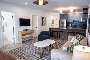 a living room with a couch and a kitchen at Escape to Revy - Beautifully Designed Condo in Revelstoke