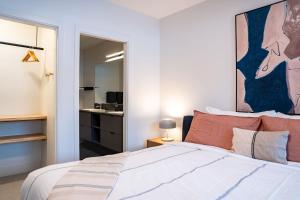 een slaapkamer met een bed met een schilderij aan de muur bij Escape to Revy - Beautifully Designed Condo in Revelstoke