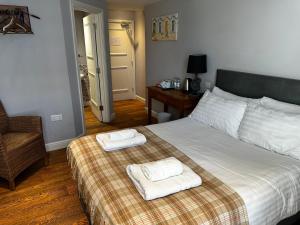 a bedroom with a bed with two towels on it at Castle Hotel in Aberaeron