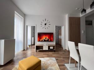 una sala de estar con un reloj grande en la pared en One Step Apartman - City Center with Self Check-In, en Szombathely