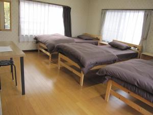 a room with four beds and a table and windows at GuestHouse AZMO - Vacation STAY 35375v in Matsue