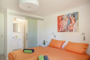 1 dormitorio con 1 cama de color naranja y una pintura en la pared en Lakeside Apartment - Seeufer Apartment, en Allensbach