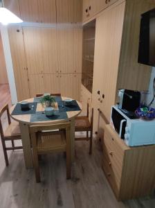 a kitchen with a table and chairs and a microwave at Presolana House in Castione della Presolana