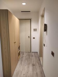 卡斯蒂奧內德拉普雷索拉納的住宿－Presolana House，一条空的走廊,有门,一间铺有木地板的房间