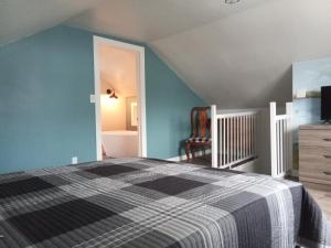 um quarto com uma cama e uma parede azul em Cozy Quincy em Bruce Mines