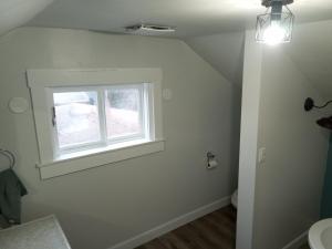 a bathroom with a toilet and a window at Cozy Quincy in Bruce Mines