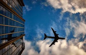 Un aereo che vola nel cielo accanto a un edificio di Wyndham Sao Paulo Ibirapuera Convention Plaza a San Paolo