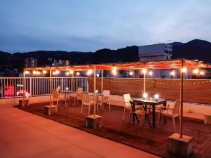 una mesa y sillas en una terraza por la noche en Calm House Beppu Kitahama - Vacation STAY 06895v, en Beppu