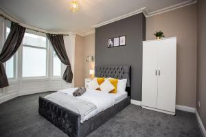ein Schlafzimmer mit einem großen Bett mit gelben Kissen in der Unterkunft Heart Of South Shields Modern Interior 2 Bed Flat in Westoe