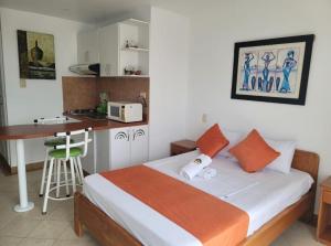 a small bedroom with a bed and a kitchen at Hotel Arco Iris in Atacames