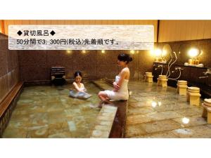 Mansuirou - Vacation STAY 32143v في Misasa: امرأة وطفل يجلسون في حوض الاستحمام