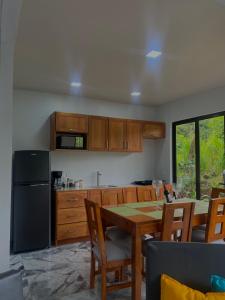 eine Küche mit einem Tisch mit Stühlen und einem Kühlschrank in der Unterkunft Luxury Villas Arenal in Fortuna