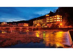 a building with a bridge over a river at night at Mansuirou - Vacation STAY 32143v in Misasa