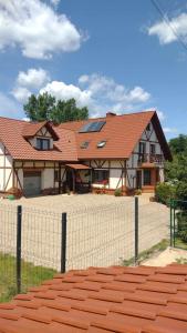 uma casa com uma cerca em frente em Agroturystyka Leśny Potok em Fredropol