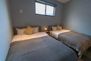 two beds in a small room with a window at Nadeshiko Machiya - Vacation STAY 27197v in Fukuoka