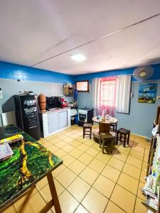 a kitchen with a table and a dining room at Toca da Mona Roots Hostel in Vitória