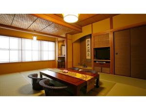 uma sala de estar com uma mesa e uma televisão em Mansuirou - Vacation STAY 32142v em Misasa