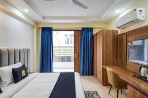 ein Hotelzimmer mit einem Bett, einem Schreibtisch und einem Fenster in der Unterkunft OYO Collection O DM 45 in Gurgaon