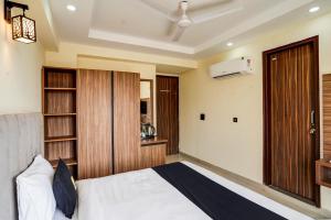 Schlafzimmer mit einem Bett und einer Holztür in der Unterkunft OYO Collection O DM 45 in Gurgaon