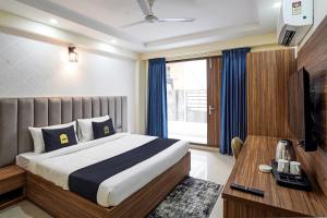 Schlafzimmer mit einem Bett, einem Schreibtisch und einem TV in der Unterkunft OYO Collection O DM 45 in Gurgaon