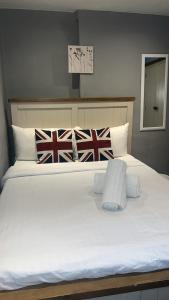 a large white bed in a bedroom with british flags at Stay In Oxford Street in London
