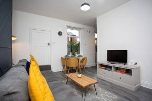 uma sala de estar com um sofá cinzento e uma mesa em The Ferndale Gf em Pallion