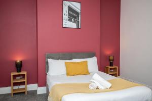 1 dormitorio con paredes rojas y 1 cama con toallas. en The Ferndale Gf, en Pallion