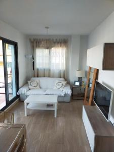 Una sala de estar con un sofá y un televisor. en ATICO MORAIRA, en Moraira