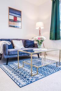 a living room with a blue couch and a glass table at Stylish 1 Bedroom Apartment in Central London in London