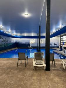 einen Pool mit zwei Stühlen davor in der Unterkunft 6BD 6BT New Clubhouse indoor pool 1 min to SDC in Branson