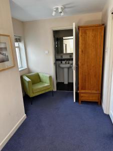 La salle de bains est pourvue d'une chaise verte et d'un lavabo. dans l'établissement Castle Hotel, à Aberaeron