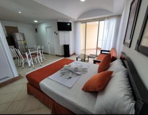 Un dormitorio con una cama con una toalla. en Hotel Arco Iris, en Atacames